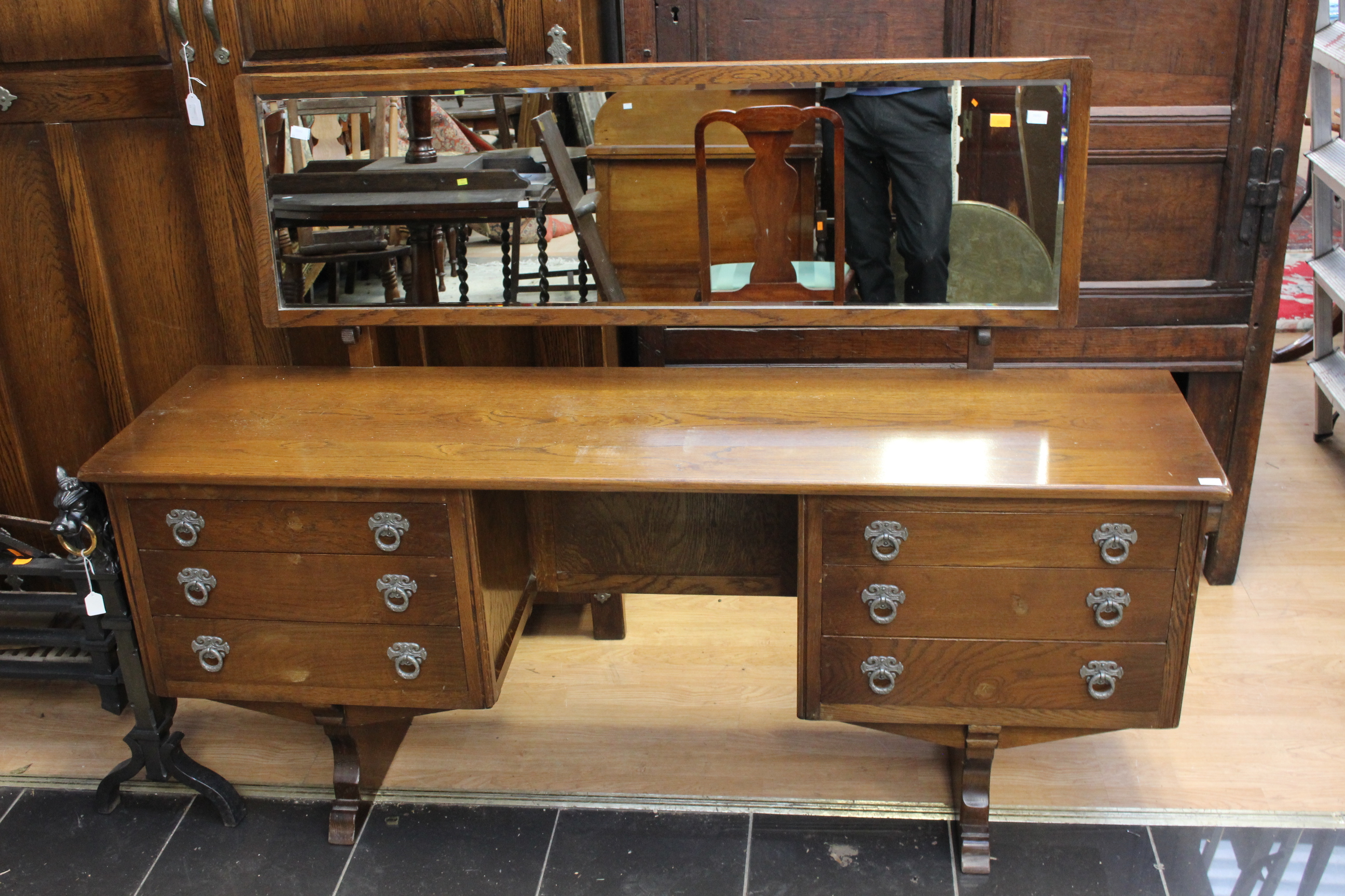 A late 20th Century oak dressing table, fitted with six drawers and having a mirrored back,