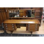A late 20th Century oak dressing table, fitted with six drawers and having a mirrored back,