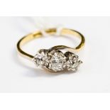 A diamond three stone illusion set 18ct yellow gold and platinum set ring,