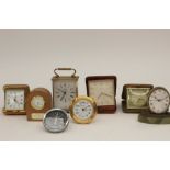 A collection of various clocks, including a miniature native oak clock, three travel clocks,