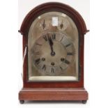 A mahogany mantle clock, silvered dial, Roman numerals,