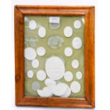 A framed collection of plaster cameos, classical scenes, etc,