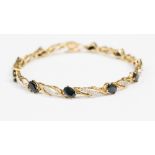 A 9ct gold bracelet claw set ten oval cut sapphires alternately with twist links, approx 7.