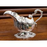 An Edwardian silver Rococo shell shaped sauce boat,