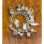 A silver charm bracelet with assorted charms,