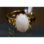 An opal yellow metal ring, the opal measuring approximately 12 x 9 mm, ring size Q,