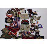 A large quantitiy of WW2 and later British and US cloth insignia, medal ribbons, Para wings,