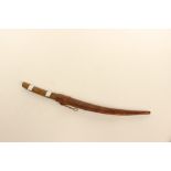 An Asian dagger with curved and decorated 30cm blade. Horn grip. In leather scabbard.