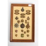 A framed collection of military buttons and badges, to include a 1914 star, 13709 Gnr.