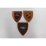 Three British Army wall plaques: each with separately applied metal badges on Corps coloured