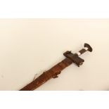 North African 19th Century Sword. In a tooled leather scabbard. Leather covered crossguard.
