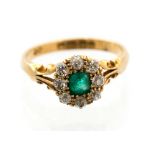 An emerald and diamond cluster 18ct yellow gold ring, the central emerald approximately 4mm by 3.