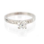 A diamond solitaire 18ct white gold ring with diamond set shoulders,