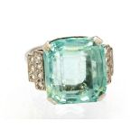 An aquamarine single stone white gold and platinum set ring with diamond set step down shoulders,