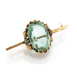 An Edwardian aquamarine single stone yellow gold brooch with two small diamonds, one each side,