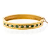 An Edwardian emerald and diamond set 18ct yellow gold hinged bangle,