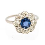 A sapphire and diamond flower head cluster ring the central round mixed cut blue sapphire measuring