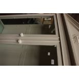 A white painted bookcase the pyramidal pediment over two glazed doors,