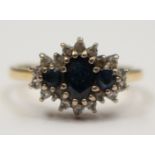 An 18ct gold cluster ring set with three sapphires and diamond surround,