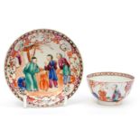 A late 18th Century Chinese tea bowl and saucer, hand painted with figures in a floral surround,
