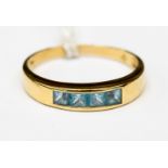 An 18ct gold ring set with four pave set square cut aquamarine stones,