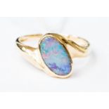 A 14k gold ring set obliquely with an oval opal, measuring 11 mm by 7 mm,