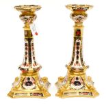 A matched pair of boxed Royal Crown Derby Old Imari 1128 pattern candlesticks,