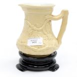 A Minton circa 1846 stoneware jug with grape and vine leaf pattern on a later glass stand