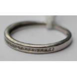 A white metal ring with channel set small diamonds, approx ring width 1.5mm.
