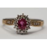 A 9ct gold, pink sapphire ring with diamond surround and diamond set shoulders,