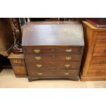 A George III oak bureau, the fall front enclosing a fitted interior,