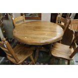 A contemporary solid oak dining table and set of four chairs,