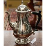 An Elizabeth II silver coffee pot in a mid 18th Century style with a pineapple finial on a domed