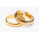 A 22ct gold wedding band approx 4mm wide with plain centre and engraved edges,