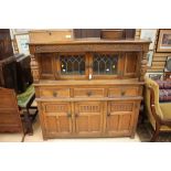 A Jacobean style oak side cabinet, the upper section with lead glazed doors,