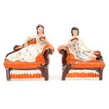 A pair of Staffordshire flatbacks of a couple reclining on a chaise (he is af)