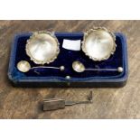 A pair of Edward VII silver circular salts with wavy raised rims, each on three pad feet,