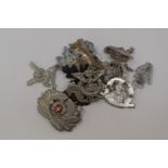 A collection of reproduction military cap badges,