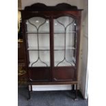 An Edwardian mahogany display cabinet fitted with two glazed doors, enclosing three fitted shelves.