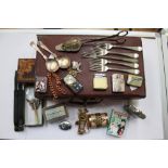 A small suitcase and assorted contents to include cigarette lighters and boxes,