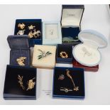 A collection of silver brooches and gold plated brooches and pins,