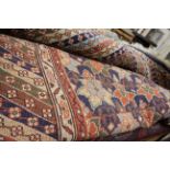 A medium sized 20th Century hand knotted woolen rug with a blue ground;