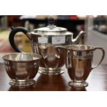 A silver three-piece tea set, in Art Deco style, comprising teapot, milk jug and sugar basin,