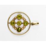 An Edwardian peridot and pearl circular openwork pendant with five round cut peridot in millegrain