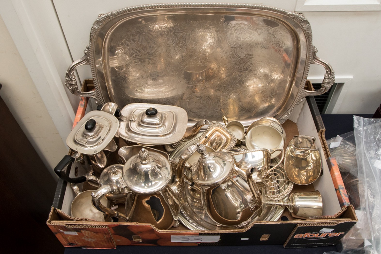 A box containing a collection of various silver plated teawares, comprising two tea services,