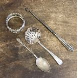 A collection of silver comprising napkin ring, sifter, a button hook and a white metal teaspoon,