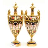 A matched pair of boxed Royal Crown Derby Old Imari 1128 pattern twin handled urns,