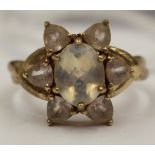 A 9ct gold ring with star shape setting of a central moonstone and six surrounding triangular