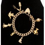 A 9ct. gold charm bracelet with seven 9ct.