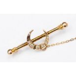 A Diamond set crescent bar brooch possibly 9ct gold unmarked set with 8old cut diamonds one missing